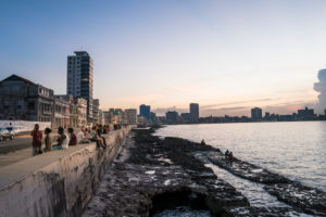 Malecon in Havana Cuba, people sitting on the Malecon, evening mood, quiet sea Malecon in Havana Cuba, people sitting on the Malecon, evening mood, quiet sea